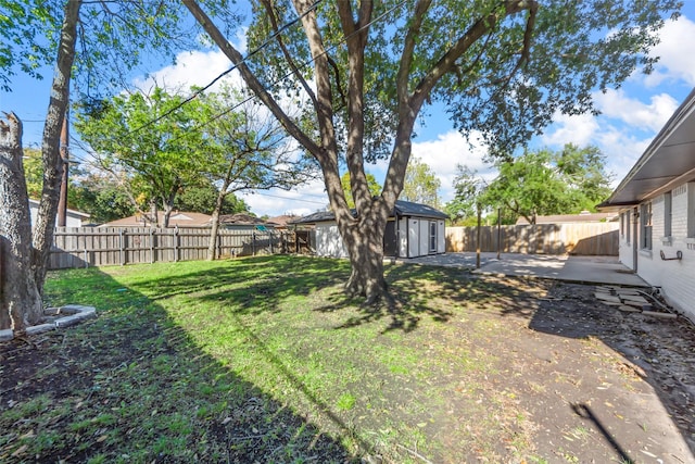 view of yard featuring a storage shed, a fenced backyard, a patio, and an outbuilding