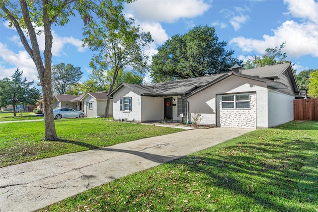 single story home featuring concrete driveway, brick siding, a front yard, and fence