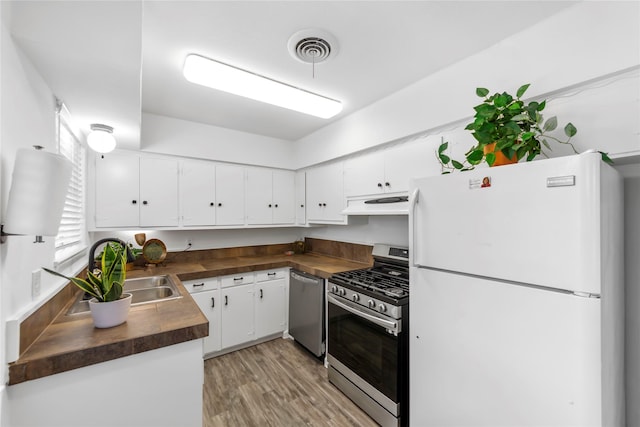 kitchen with under cabinet range hood, visible vents, appliances with stainless steel finishes, and white cabinets