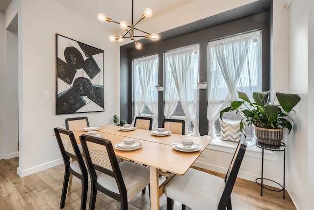 dining area with a healthy amount of sunlight, light wood-style flooring, and baseboards