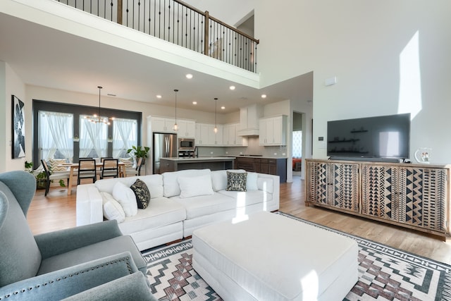 living room with light wood-type flooring, a notable chandelier, and recessed lighting