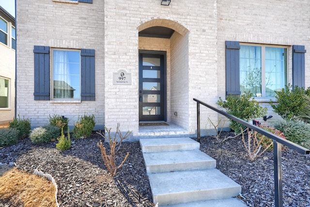 view of exterior entry with brick siding