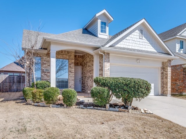 view of front of property with a garage, driveway, a shingled roof, fence, and brick siding