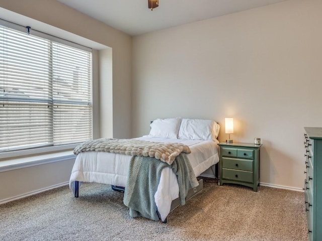 bedroom featuring baseboards and light colored carpet