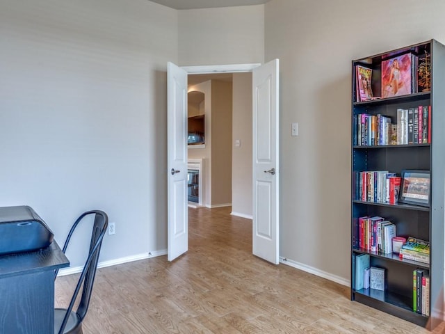 office area with baseboards and wood finished floors