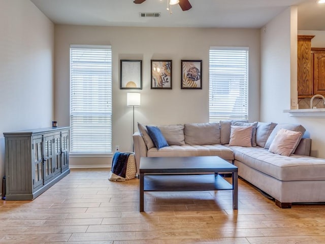 living area with light wood-style floors, a healthy amount of sunlight, and visible vents