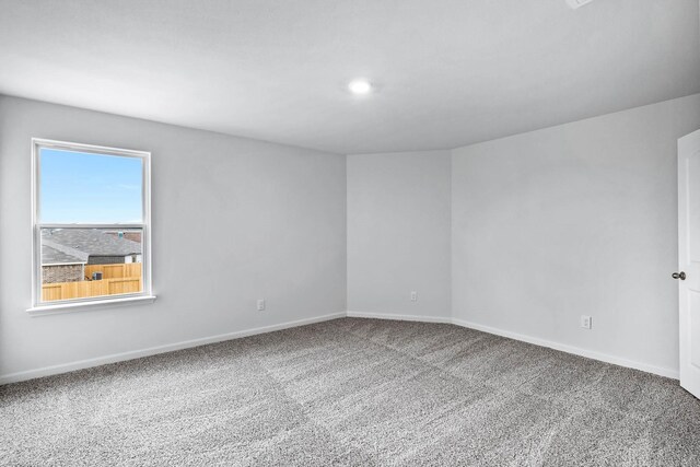 empty room with carpet and baseboards