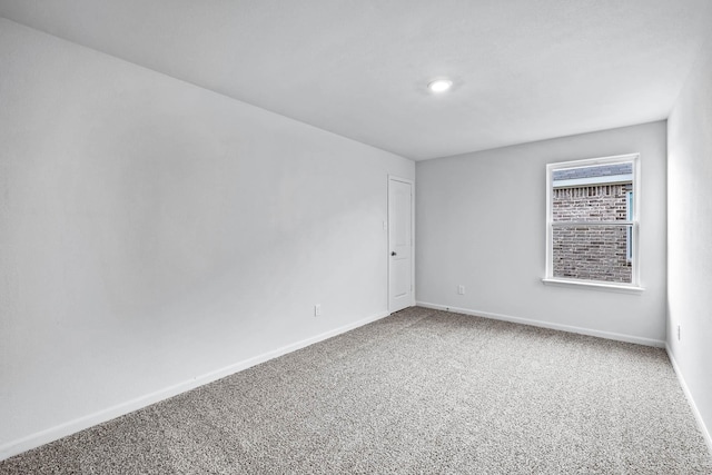 spare room featuring baseboards and carpet flooring