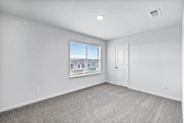 unfurnished room featuring carpet flooring, visible vents, and baseboards