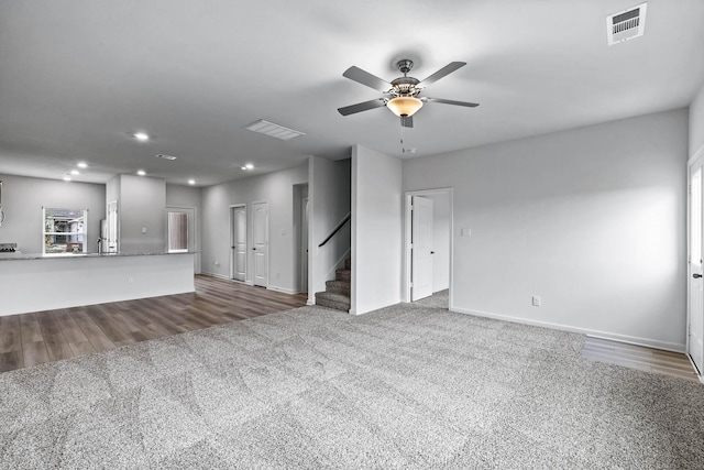 unfurnished living room featuring ceiling fan, recessed lighting, carpet floors, visible vents, and stairs