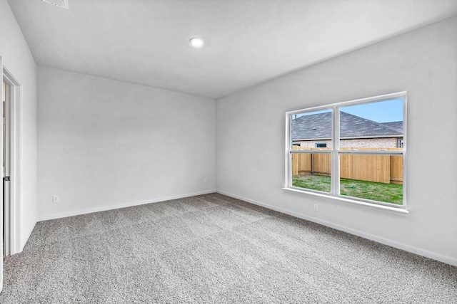 carpeted spare room featuring baseboards