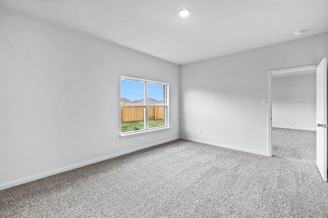 carpeted empty room with baseboards