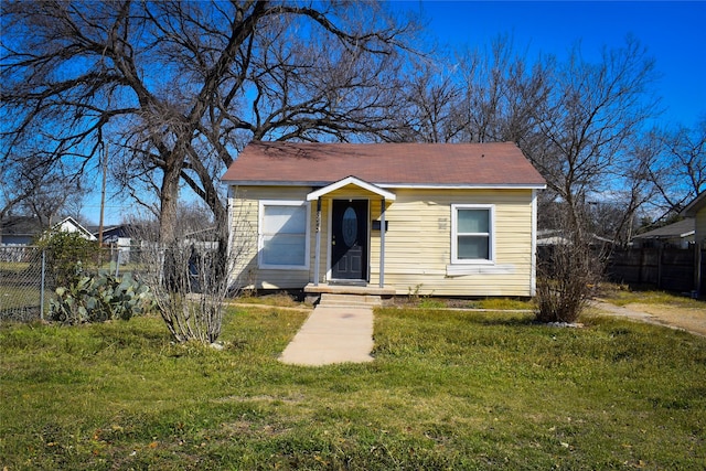 bungalow-style home featuring fence and a front lawn