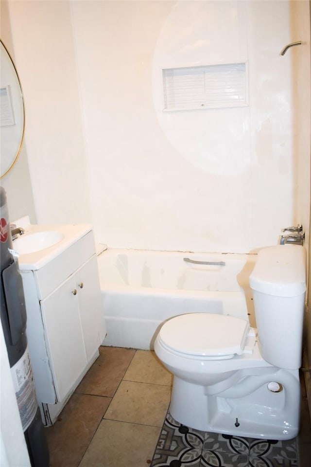 bathroom with toilet, vanity, and tile patterned floors