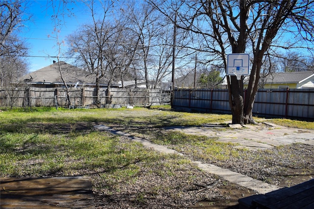 view of yard with a fenced backyard and basketball court