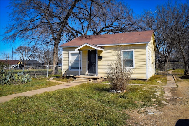 bungalow featuring a front yard and fence