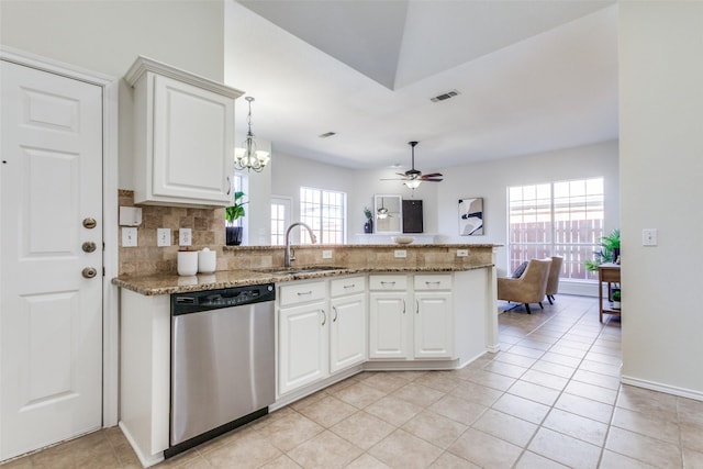 kitchen featuring a sink, white cabinets, stainless steel dishwasher, backsplash, and pendant lighting