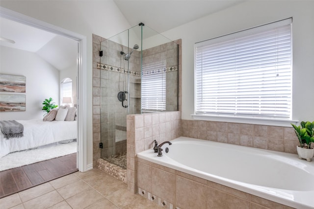 ensuite bathroom with lofted ceiling, tile patterned floors, ensuite bathroom, a shower stall, and a bath