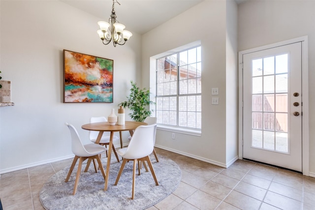 dining space featuring an inviting chandelier, baseboards, and light tile patterned floors