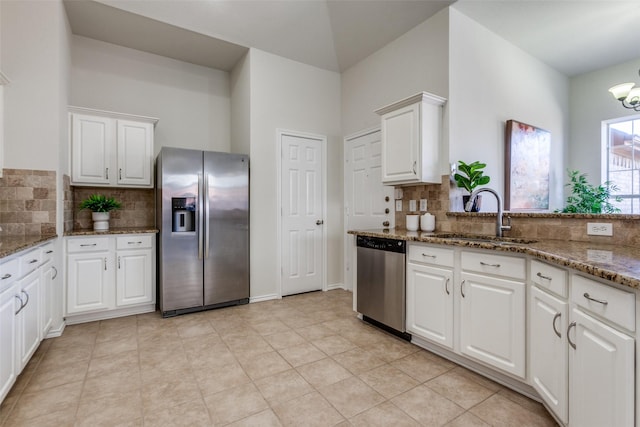 kitchen featuring stainless steel appliances, stone counters, a sink, and white cabinets