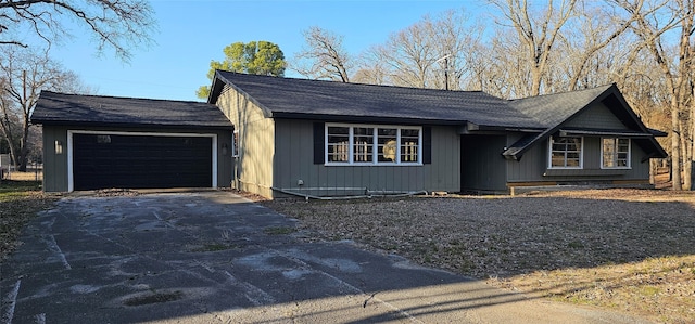 single story home with an attached garage and aphalt driveway