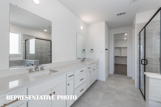 bathroom with a spacious closet, a sink, visible vents, and a shower stall