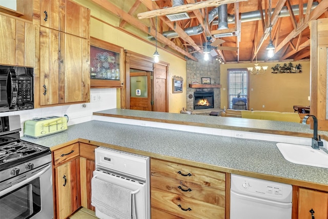 kitchen with a fireplace, hanging light fixtures, a sink, stainless steel gas range, and black microwave