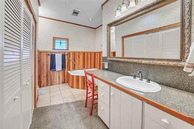 bathroom with a garden tub, a wainscoted wall, vanity, a closet, and wallpapered walls