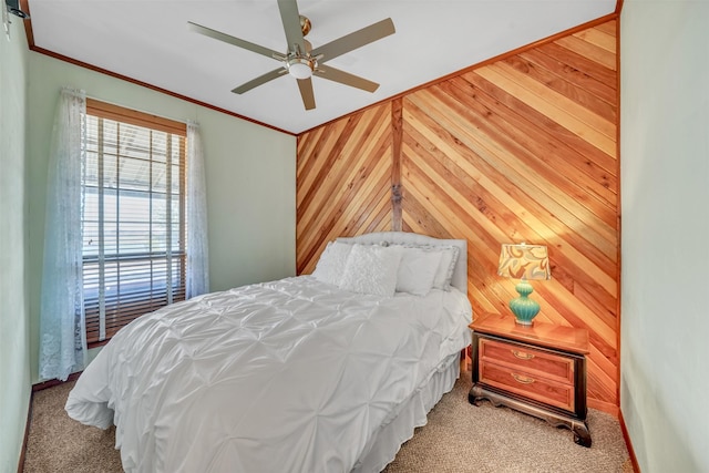 bedroom featuring carpet, wooden walls, ornamental molding, and a ceiling fan