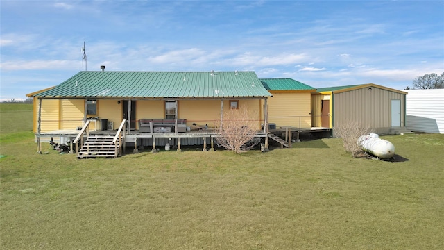 rear view of property with metal roof and a lawn