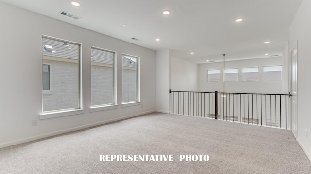 unfurnished room with carpet floors, baseboards, visible vents, and recessed lighting