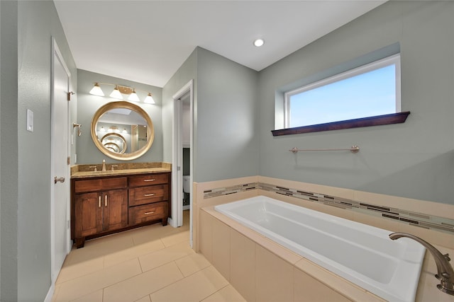 bathroom with tile patterned flooring, a garden tub, and vanity