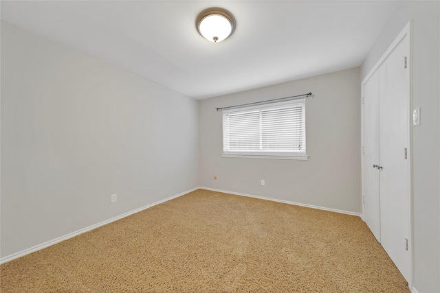 unfurnished bedroom featuring carpet floors, a closet, and baseboards