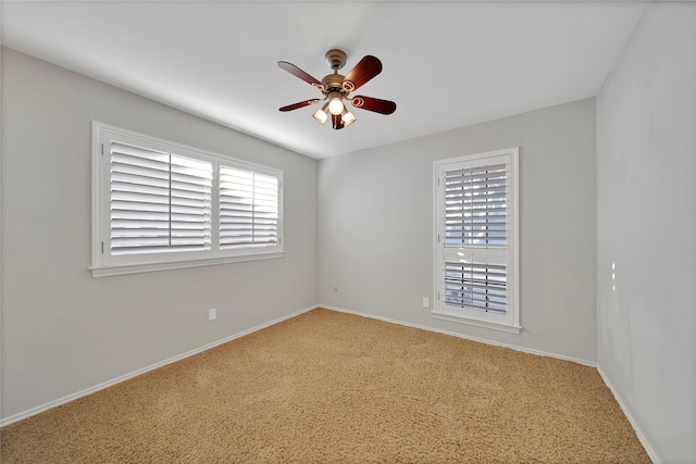 spare room featuring a wealth of natural light, ceiling fan, and baseboards