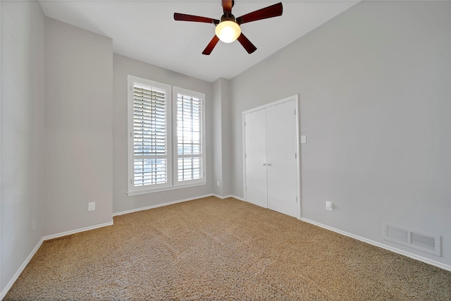 carpeted empty room with ceiling fan, visible vents, and baseboards