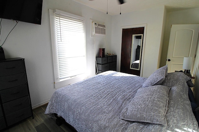 bedroom with a wall unit AC and wood finished floors