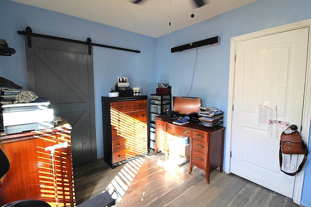 office featuring a barn door and dark wood-type flooring