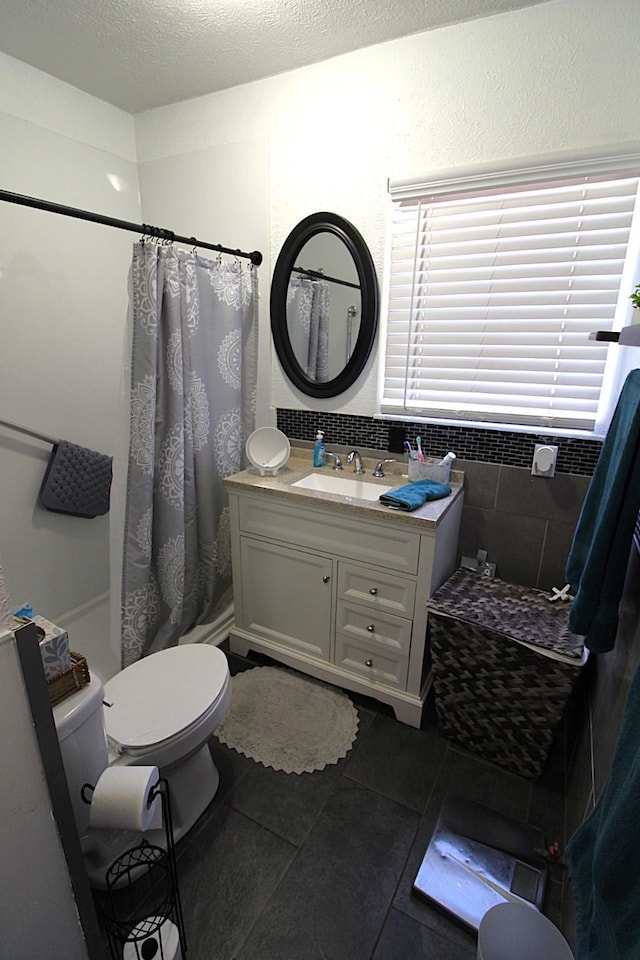 full bathroom featuring toilet, a shower with curtain, tile patterned flooring, a textured ceiling, and vanity