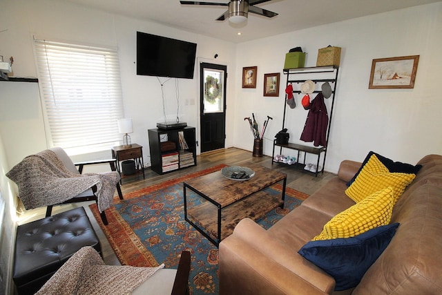 living area featuring a ceiling fan and dark wood-type flooring