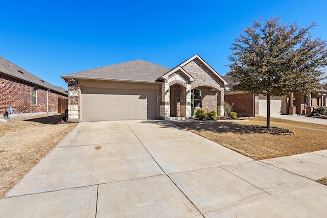 view of front of property with a garage, stone siding, brick siding, and driveway