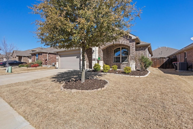 view of front of home with brick siding, central air condition unit, an attached garage, fence, and driveway