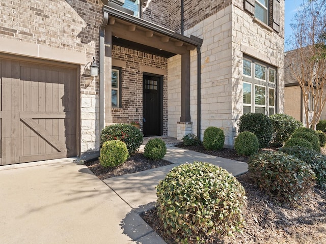 property entrance featuring brick siding and an attached garage