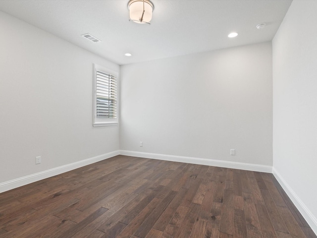 empty room with visible vents, baseboards, dark wood finished floors, and recessed lighting