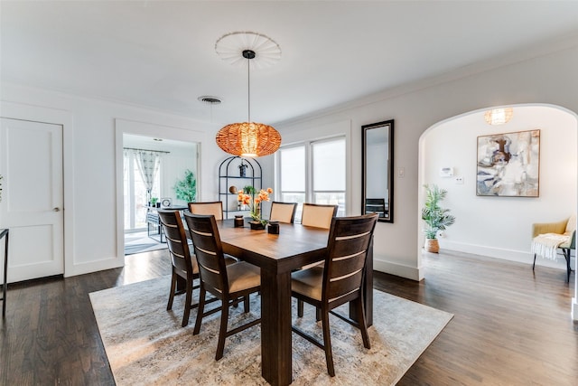 dining area with ornamental molding, wood finished floors, and baseboards