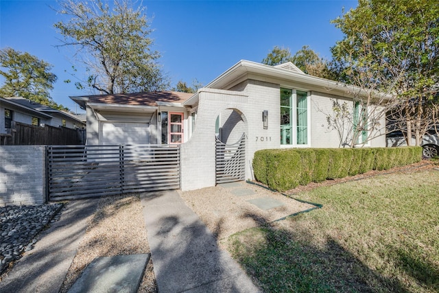 view of front of house featuring brick siding, a front yard, fence, and a gate