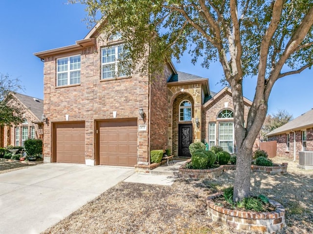 view of front of house featuring a garage, cooling unit, concrete driveway, and brick siding