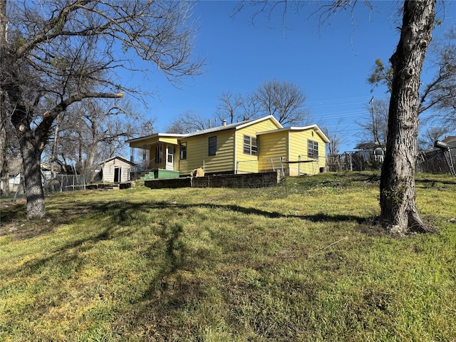 view of side of property featuring a lawn and fence