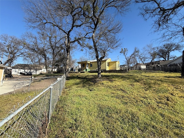 view of yard with concrete driveway and fence