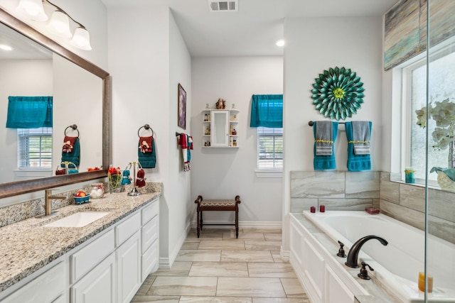 full bath featuring baseboards, visible vents, a bath, and vanity