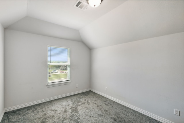 additional living space featuring vaulted ceiling, carpet floors, visible vents, and baseboards